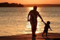2774946-un-adulto-e-un-bambino-a-piedi-su-un-bacino-al-tramonto.jpg